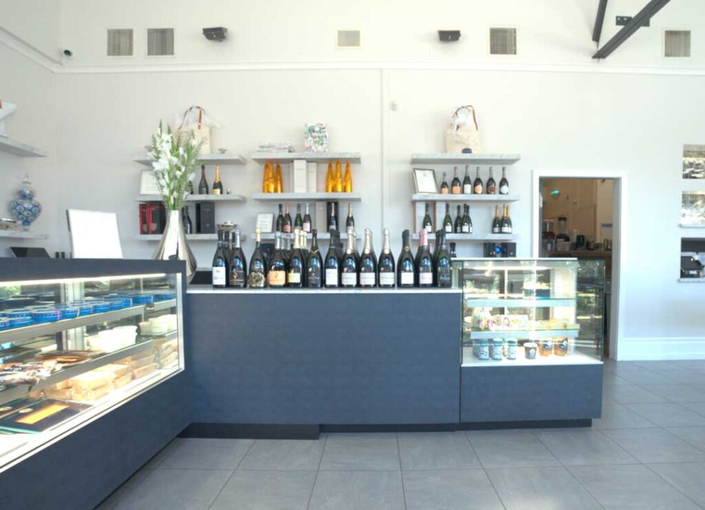 a boutique interior with grey refrigerated display counters, filled with Petrossian products, including caviar and smoked salmon